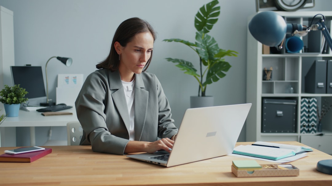 Woman working on a laptop at a desk.