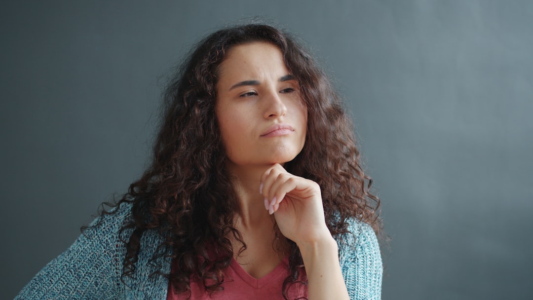 Young woman with curly hair looking thoughtful